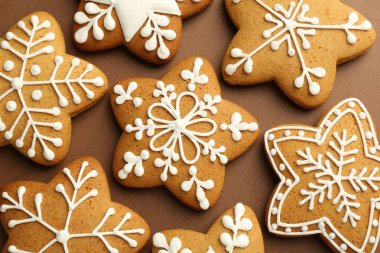 Kahverengi arka planda kremalı lezzetli Noel kurabiyeleri.