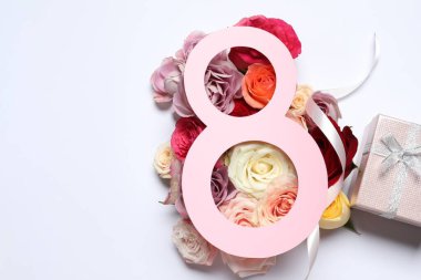 8 Mart tebrik kartı tasarımı, beyaz arka planda güller ve hediye kutusu, üst manzara. Uluslararası Kadınlar Gününüz kutlu olsun.