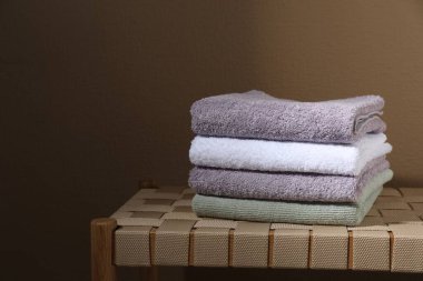 Bej duvarın yakınındaki hasır bankta Terry havluları istiflenmiş. Mesaj için yer var.