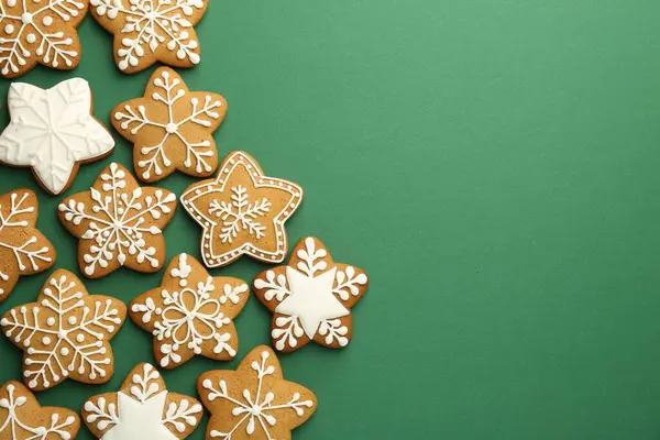 Yeşil arka planda kremalı lezzetli Noel kurabiyeleri. Metin için boşluk