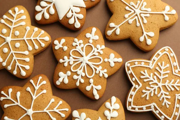 Kahverengi arka planda kremalı lezzetli Noel kurabiyeleri.