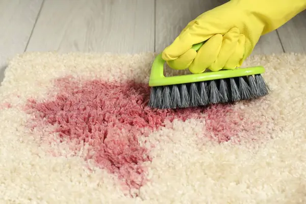 Bej halıdaki lekeyi çıkaran kadın, yakın plan.