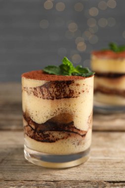 Lezzetli tiramisu ve naneli bardaklar ahşap masada, yakın plan.