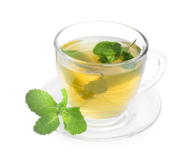 Cam fincanda taze yeşil çay, beyaz üzerinde izole edilmiş nane ve çay tabağı.