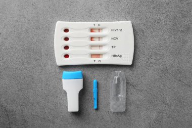 Tek kullanımlık çoklu enfeksiyon ekspres test kiti gri masada, düz yatıyordu