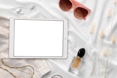 Düz kompozisyon ve beyaz kumaş üzerine modern tablet. Metin için boşluk