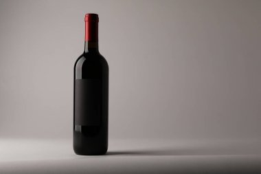 Hafif arka planda bir şişe lezzetli kırmızı şarap, metin için yer