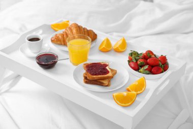 Yatakta nefis bir kahvaltı tepsisi, yakın plan.