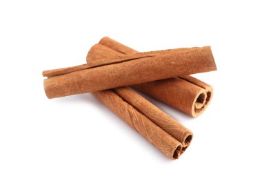 Beyaz üzerine izole edilmiş üç aromatik tarçın çubuğu.