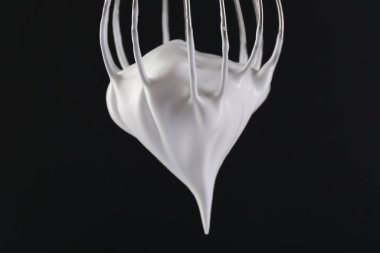 Siyah arka planda krem şantili çırpma çırpma, yakın plan