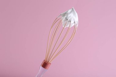 Pembe arka planda krema çırpılmış çırpma