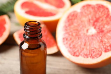 Şişede greyfurt yağı ve masada meyveler, yakın çekim. Metin için boşluk