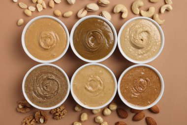 Bir sürü lezzetli fındık ezmesi tabakta ve fındık bej masada, düz yerde