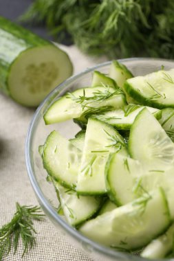 Salatalığı cam kaseyle kes, masaya koy, yakından.