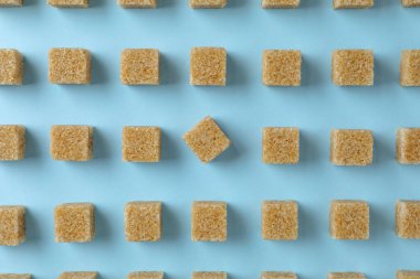 Açık mavi zemin üzerinde kahverengi şeker küpleri, düz yatıyordu