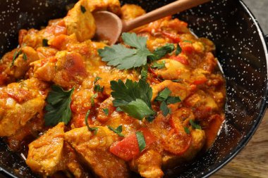 Lezzetli körili tavuk tabakta ve kaşıkta, yakın plan.