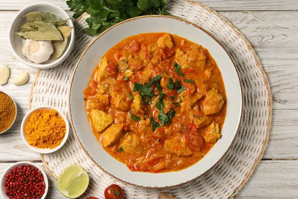 Lezzetli tavuk körisi ve ahşap masa üzerindeki malzemeler, düz yatıyordu.