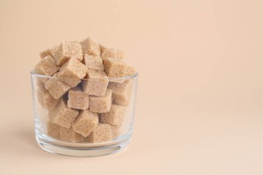Esmer şeker küpleri bej arka planda, yakın plan. Metin için boşluk