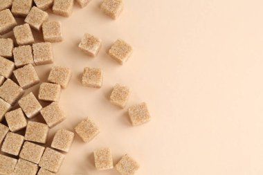 Esmer şeker küpleri bej arka planda, üst manzara. Metin için boşluk