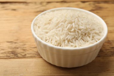 Tabakta çiğ basmati pilavı, ahşap masada, yakın plan.