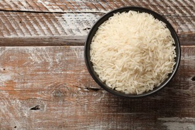 Tabakta çiğ basmati pilavı, ahşap masa, üst manzara. Metin için boşluk