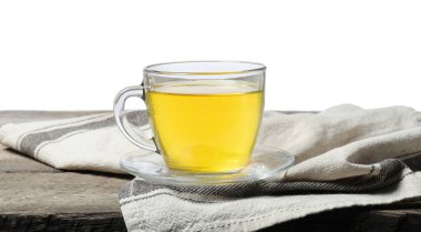 Beyaz arka planda, tahta masada fincanda yeşil çay tazeleniyor.