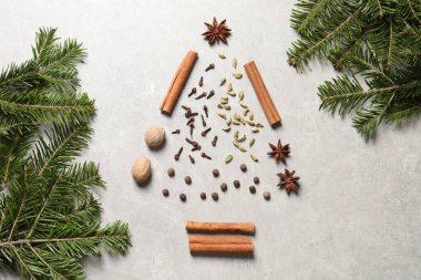 Noel ağacı farklı baharatlardan ve köknar dallarından yapılmıştır açık gri desenli masa üzerinde, düz uzanır
