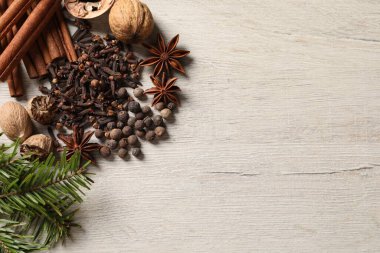 Farklı baharatlar, fındık ve köknar dalları tahta masada, düz yerde. Metin için boşluk