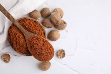 Nutmeg tozu ve tohumlar beyaz masada, düz yerde. Metin için boşluk