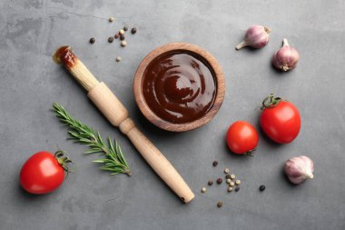 Düz kompozisyon ve lezzetli barbekü sosu gri desenli masada.
