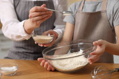 Ekmek yapıyorum. Anne ve kızı, un ve kuru mayayı mutfaktaki ahşap masada kaseye koyuyorlar.