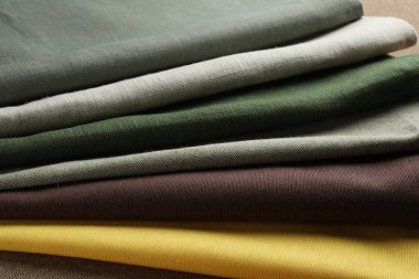 Kahverengi kumaş üzerinde birçok farklı kumaş, yakın plan.