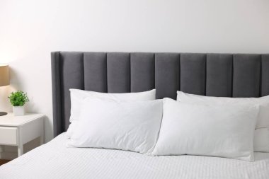 Evdeki yatakta yumuşak beyaz yastıklar ve çarşaflar.