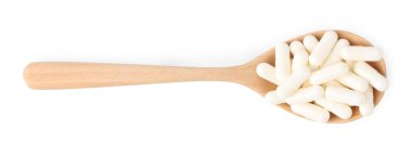 Tahta kaşıkta vitamin kapsülleri beyaz, üst görünümde izole.