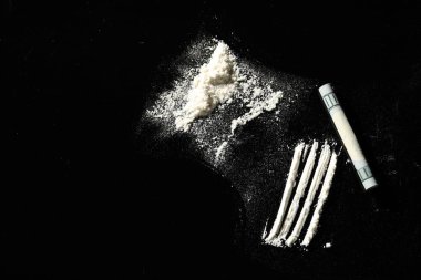 Uyuşturucu ve dolar banknotu siyah arka planda, düz yatıyordu. Metin için boşluk