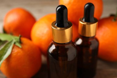 Mandalina yağı şişeleri ve taze meyveler masanın üstünde, yakın plan.