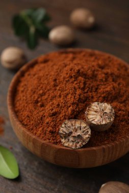 Nutmeg tozu ve yarım tohumlar ahşap masada, yakın plan.