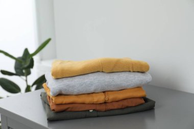 Sıralama ve düzenleme. İçerideki çekmecelere farklı katlanmış giysiler yığılmış.