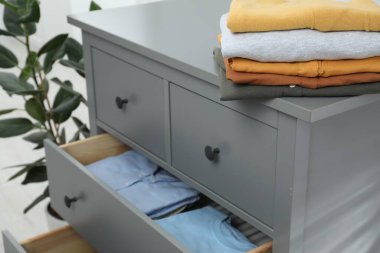 Sıralama ve düzenleme. İçinde farklı katlanmış giysiler olan çekmeceler.