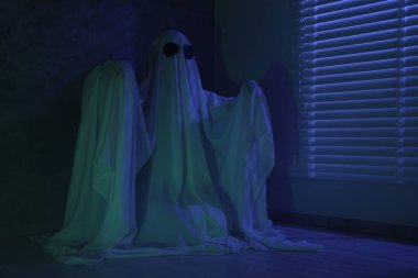 Ürkütücü hayalet. Pencerenin yanında, mavi ışıkla kaplanmış kadın.