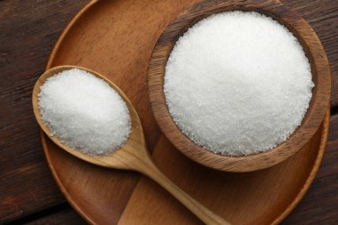 Kase içinde granüle şeker ve tahta masa üzerinde kaşık, üst manzara