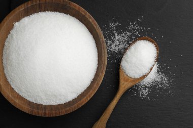 Kapta granüle şeker ve siyah masada kaşık, düz yatıyordu.