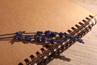 Güzel korunmuş lavanta çiçekleri ve defter ahşap masada, yakın plan.
