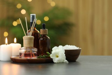 Farklı spa ürünleri içeren kompozisyon ve açık gri masa üzerinde mum yakma, metin için boşluk