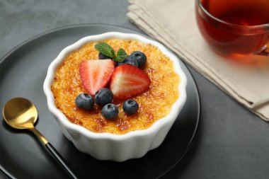 Böğürtlenli nefis creme brulee ve gri masadaki nane şekeri, yakın plan