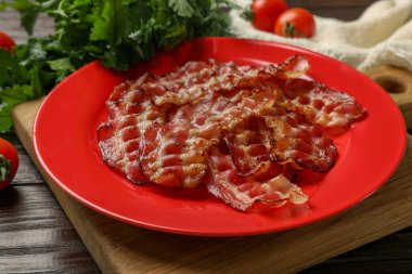 Kızarmış domuz pastırması, domates ve maydanozla ahşap masa, yakın plan.