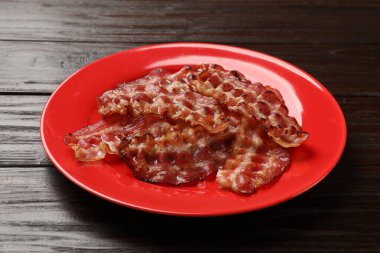 Ahşap masada kızarmış pastırma dilimleri ve yakın plan.