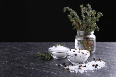 Taze kekikli tuz ve koyu gri desenli masada biber. Metin için boşluk