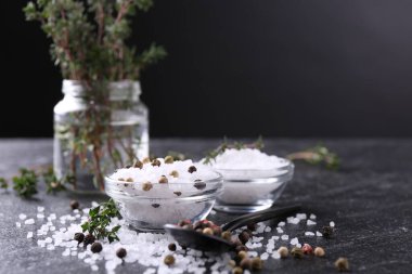 Taze kekikli tuz ve koyu gri desenli masada biber. Yakın plan.