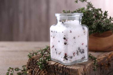 Cam kavanozda biberli tuz ve ahşap masada kekik, metin için boşluk.